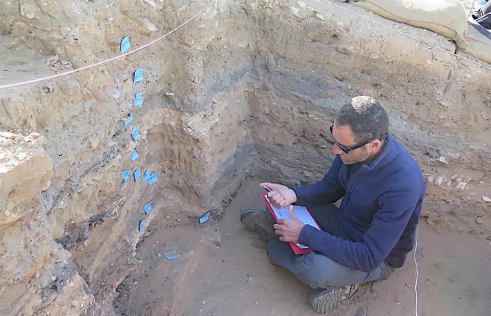 A researcher studying sedimentary layers preserved in a garbage pit of the ancient city of Elusa in modern Israel.