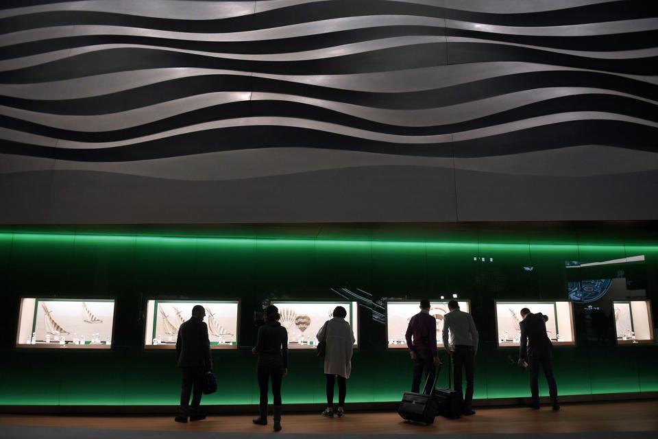 Visitors are contemplating the windows of a luxury watch brand at the Baselworld fair.