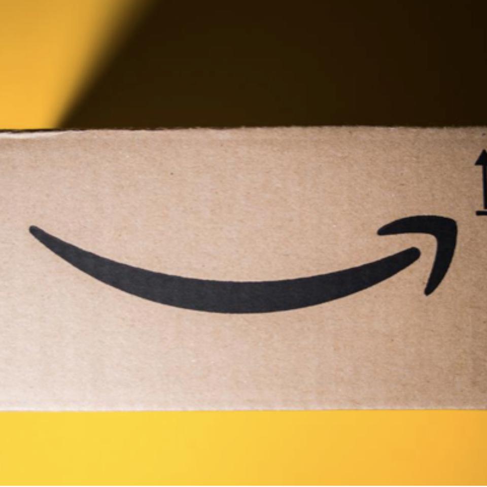 Amazon's Cardboard box against yellow with smile logo on it