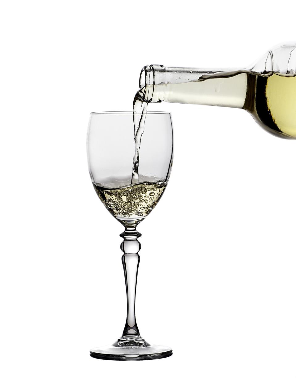 White wine glass and bottle on a white background.