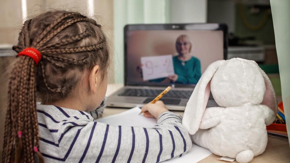 Pretty stylish schoolgirl studying math during her online lesson at home, self-isolation