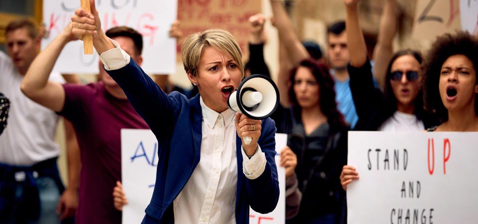 Woman shouting through megaphone while marching on protests protest.