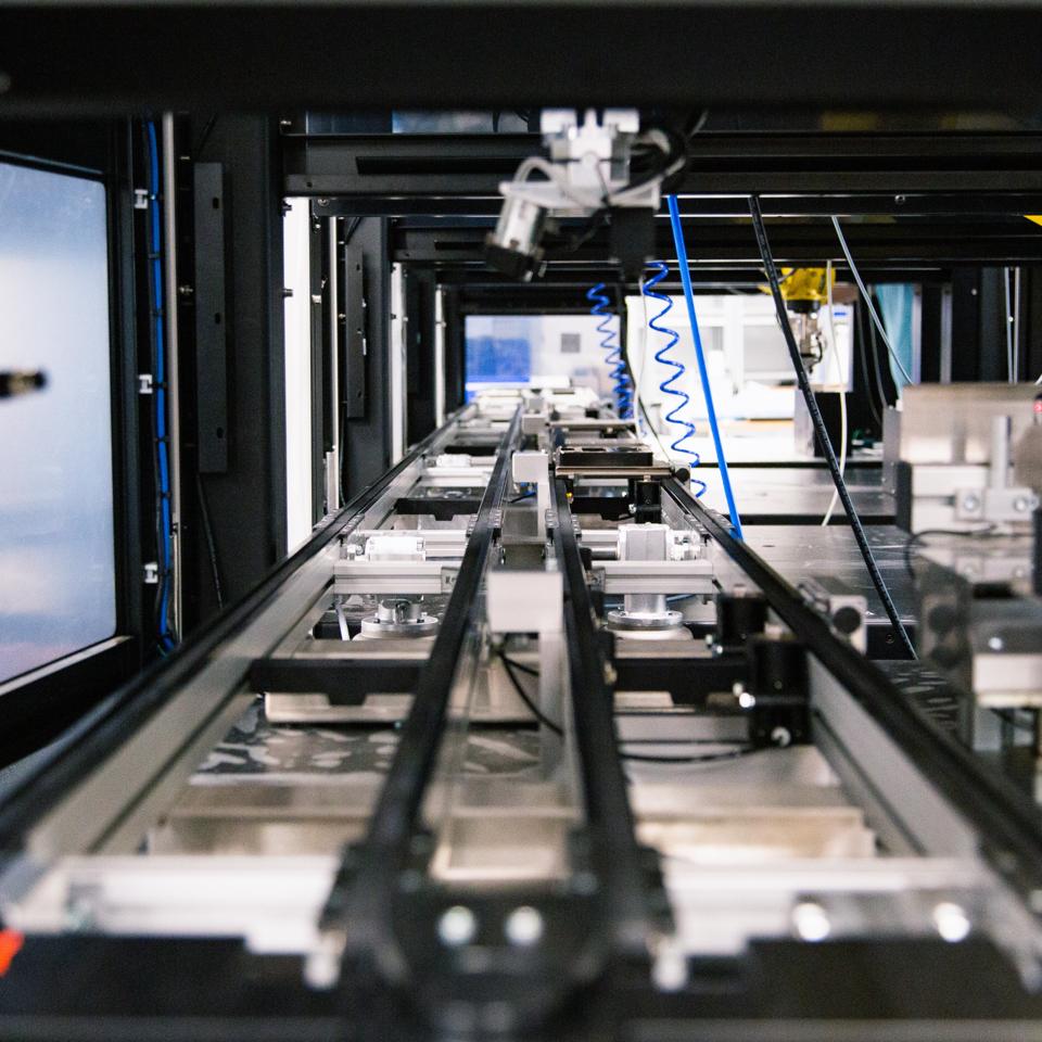 The inside of a robotic cell that assembles an electronic component of a product.