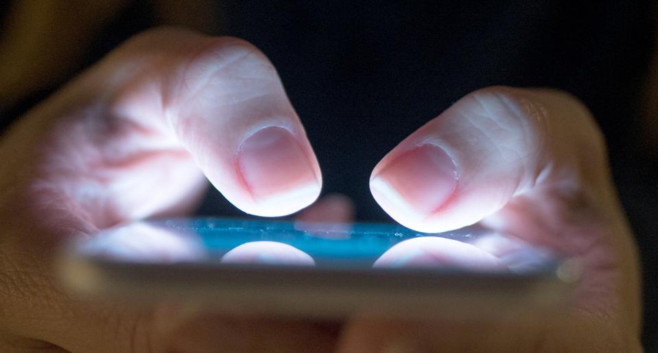 Female using her mobile phone outside at night