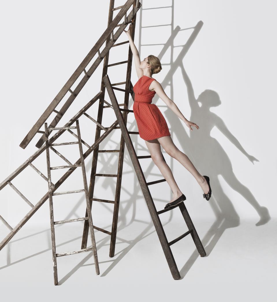 Business woman climbing up ladders construction