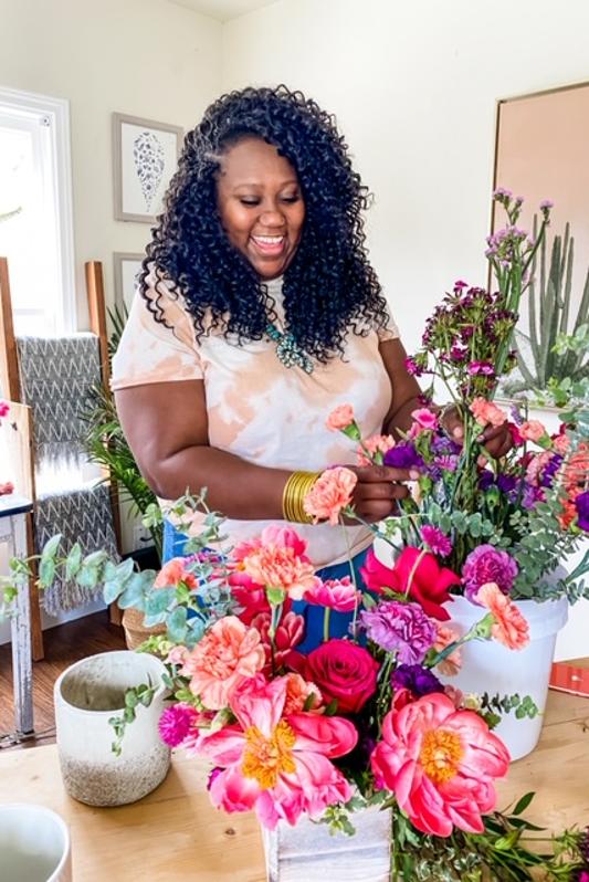 Bree Clark, founder and creative director of The Iman Project, arranging vibrant floral bouquets.