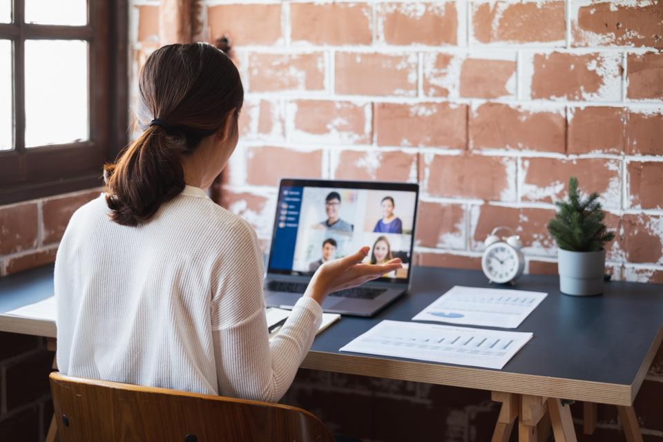 Young Asian businesswoman work at home and virtual video conference meeting with colleagues business people, online working, video call due to social distancing at home office