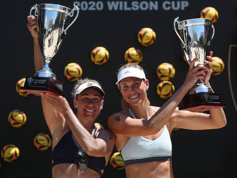 April Ross (l.) and Alix Klineman (r.) host their championship trophies from the 2020 AVP Wilson Cup.