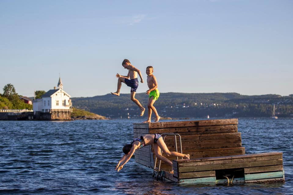 Children jump into the Oslo fjord in Norway as Covid lockdown rules ease