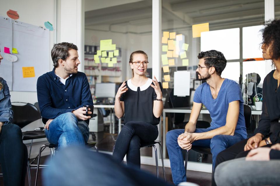 Young woman sharing her ideas with team in meeting
