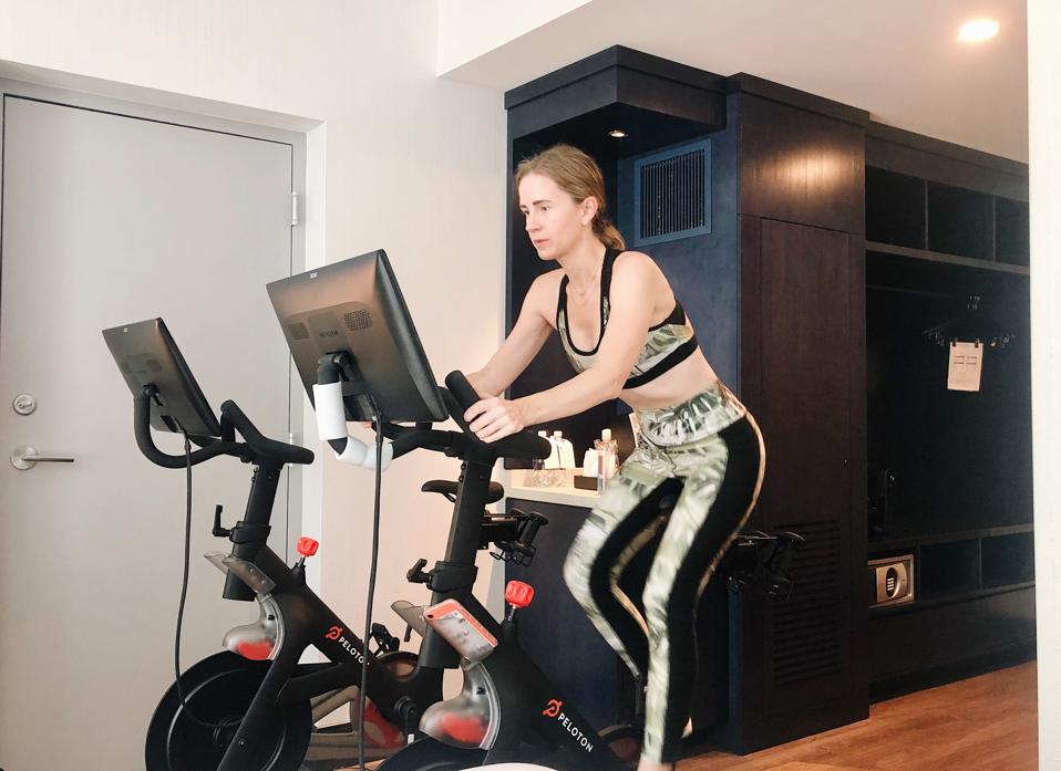 A woman on a stationary bike in a hotel.