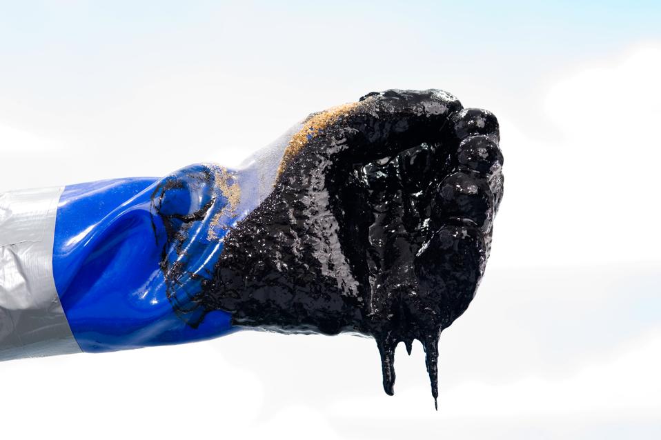 Oiled covered gloved hand during Oil spill clean up
