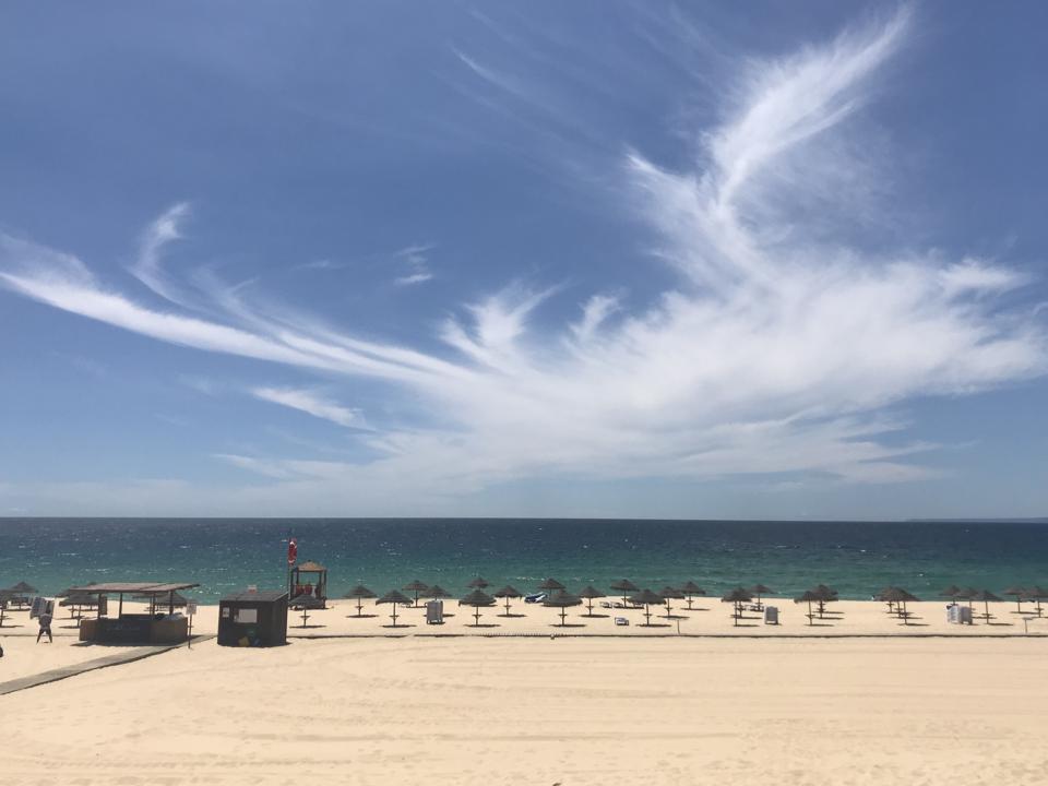 There are dramatic clouds in the sky over the Atlantic Ocean in Comporta, Portugal.