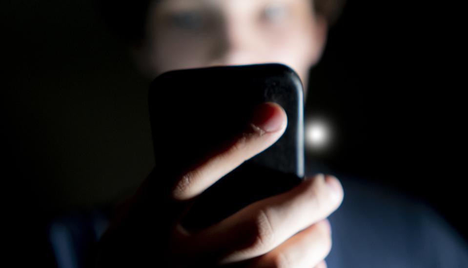Man using phone in dark