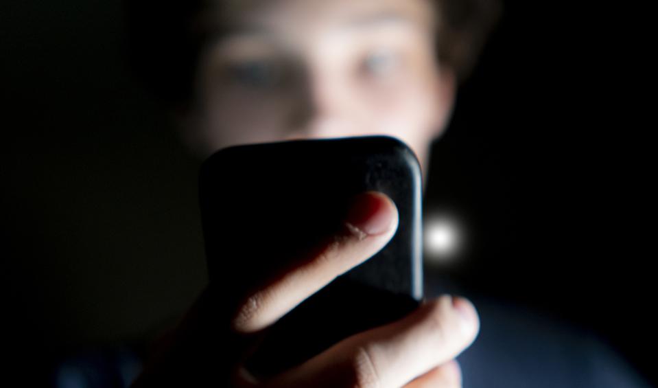 Young man on mobile phone late at night