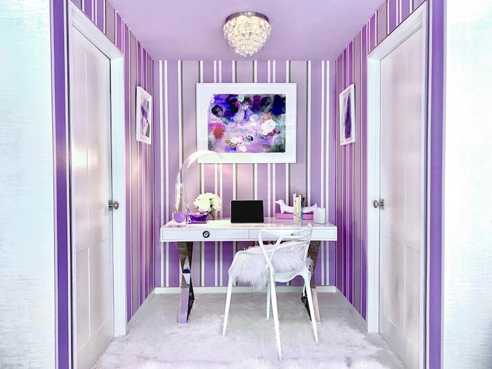 Homeschooling nook with purple and white striped wallpaper, a white desk and chair.