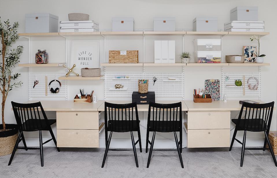 Desks and chairs under shelves and peg boards.