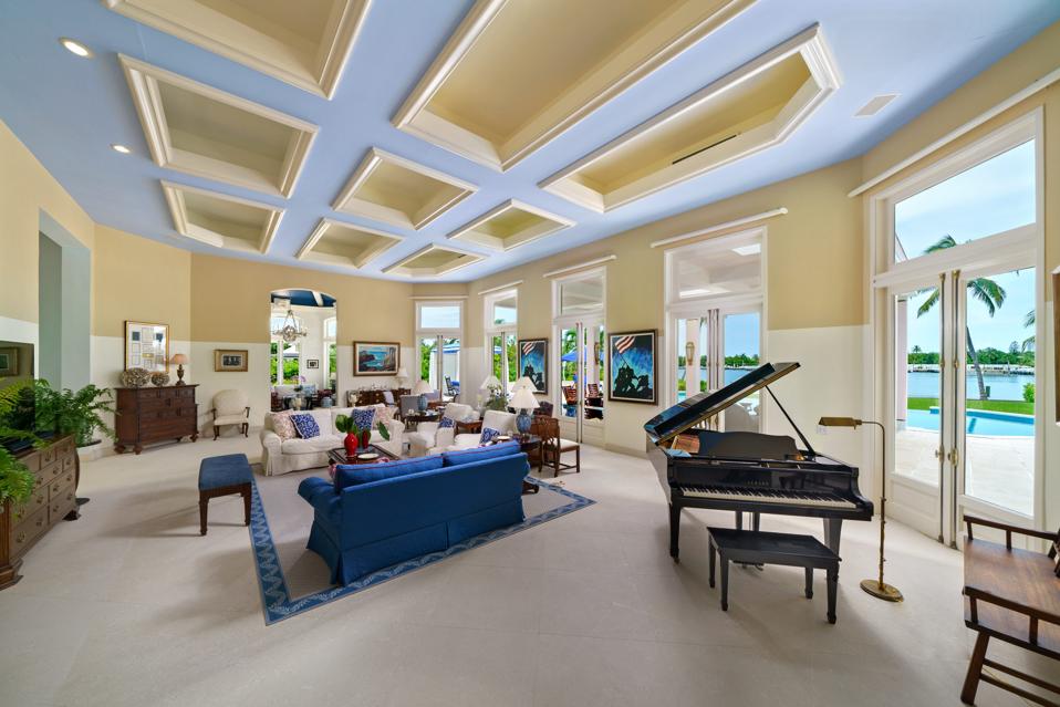 Living room with piano with view of swimming pool
