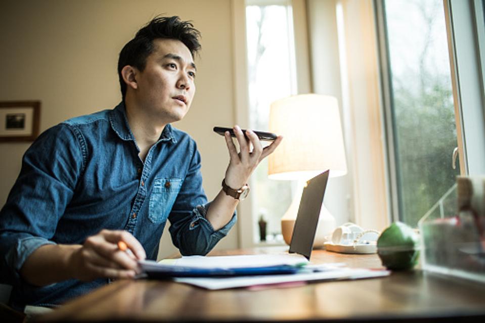 Man talking on a phone at his desk.