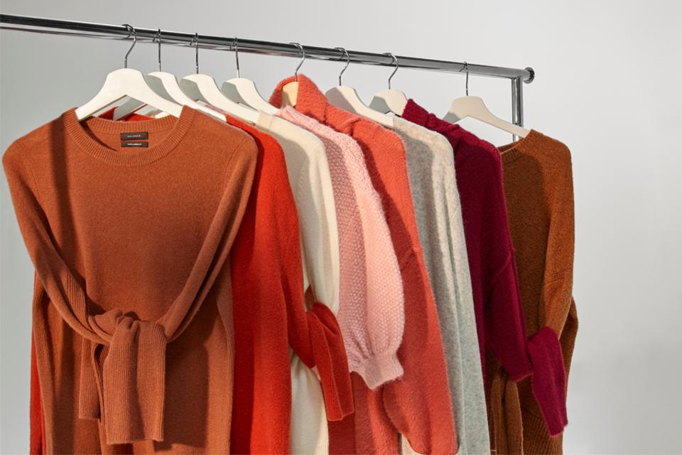 Sweaters hanging on a rack in fall colors