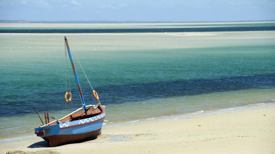Photograph of a dhow sitting on the shoreline of an ocean