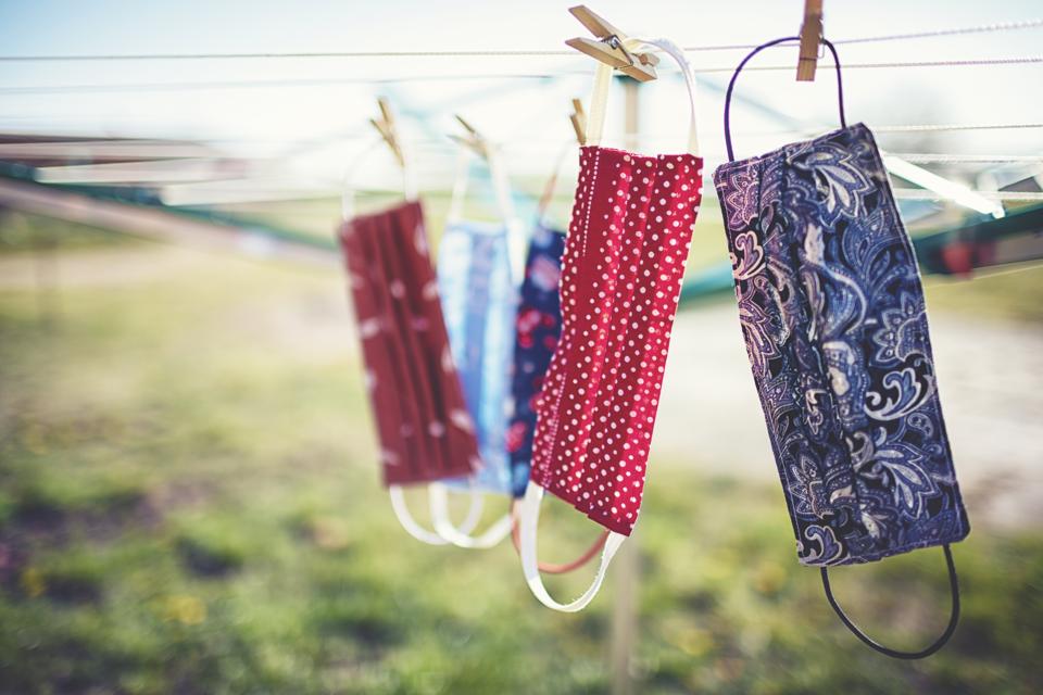 Les masques buccaux et nasaux auto-cousus contre le virus corona sont suspendus à la corde à linge pour sécher.