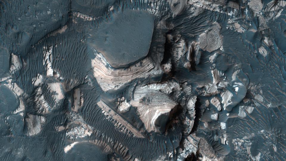 Color photo from above showing jumbled boulders with pale layers visible on their sides and dark tops.
