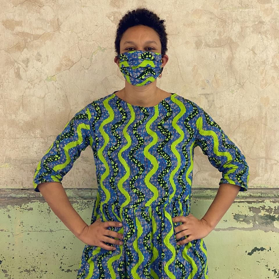 Designer Dinzi Amobi avec masque et robe en tissu imprimé wax africain