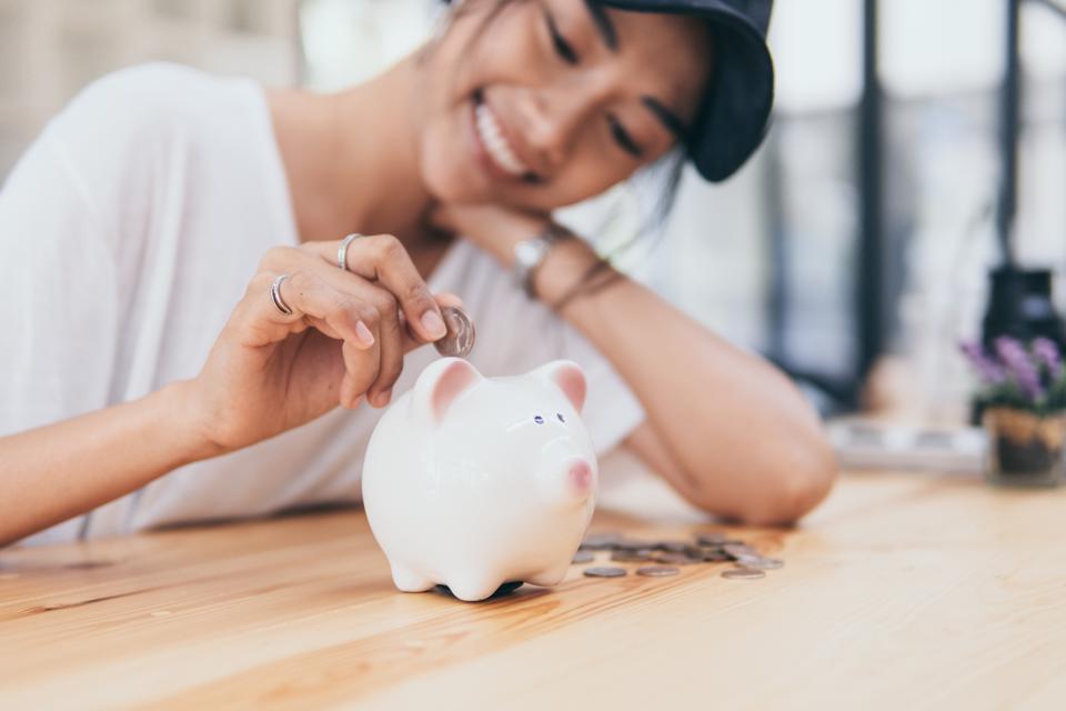 Piggy Bank for saving money.Hand holding money for savings and financial management.