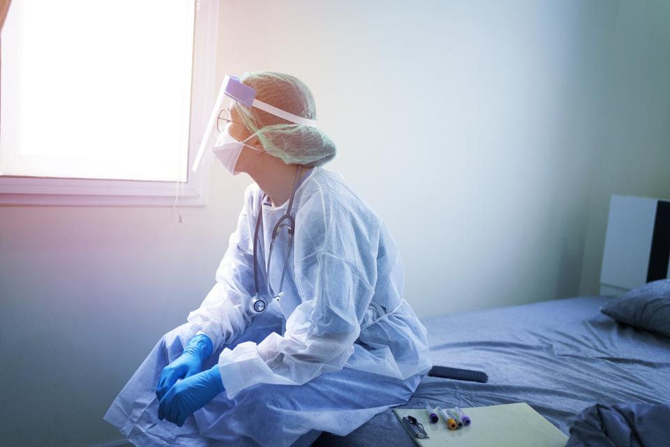 Doctor wearing PPE (Personal Protection Equipment ) or Isolation grown Suite feeling down and sad for fighting covid-19 (Corona virus)