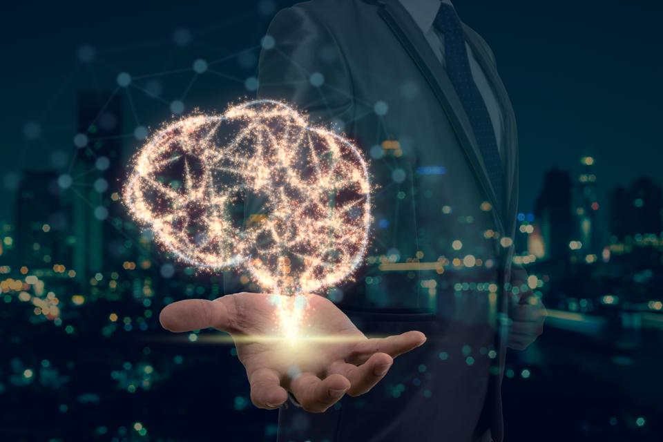 Double exposure of Businessman hand holding the brain base on sparkle over photo blurred of cityscape background, Artificial Intelligence or AI concept