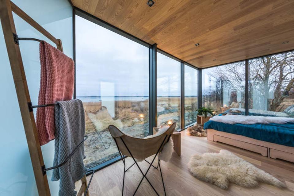 Sumptuous interiors inside a cabin with glass doors overlooking the land.