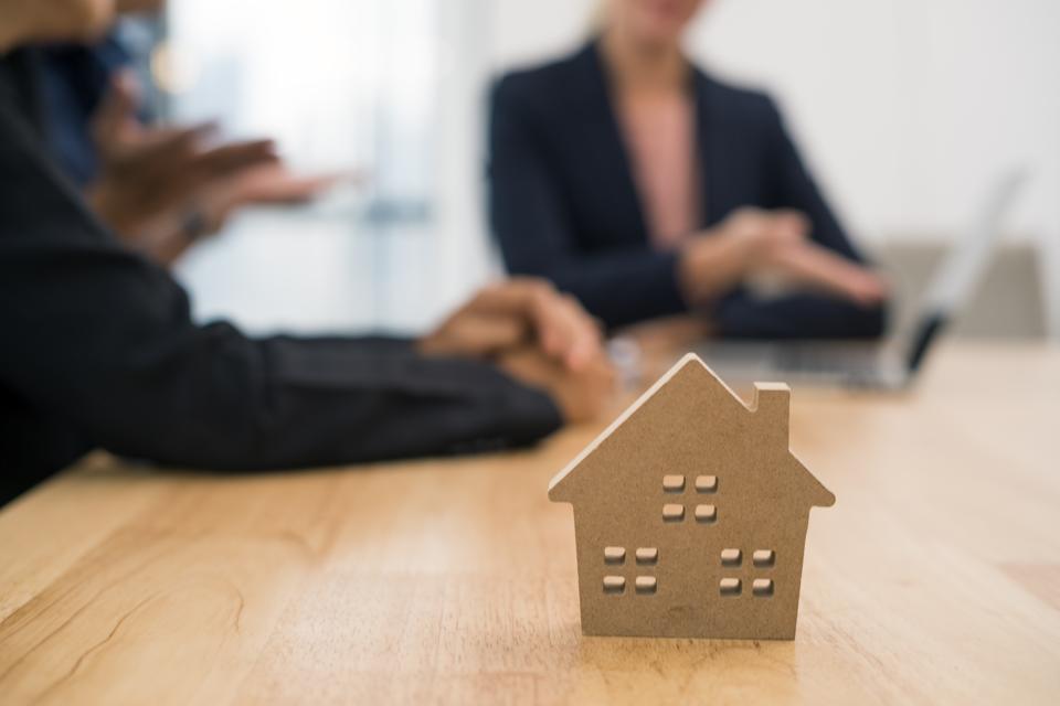 saleswoman presenting real estate to couple