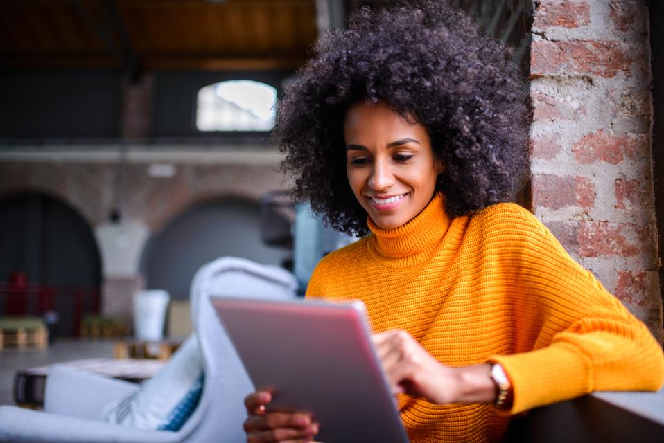Smiling woman using digital tablet.