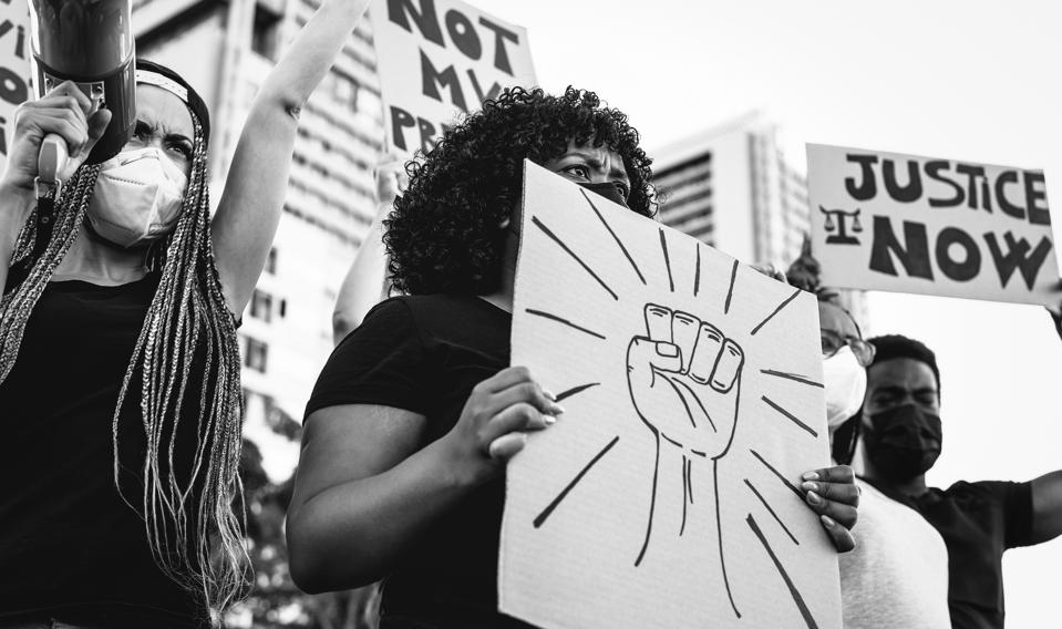 Mouvement militant international de protestation protestant contre le racisme et luttant pour la justice - Des manifestants de différentes cultures et des races protestent dans la rue pour l'égalité des droits