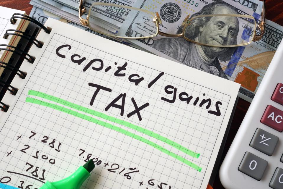 Notebook with capital gains tax sign on a table.