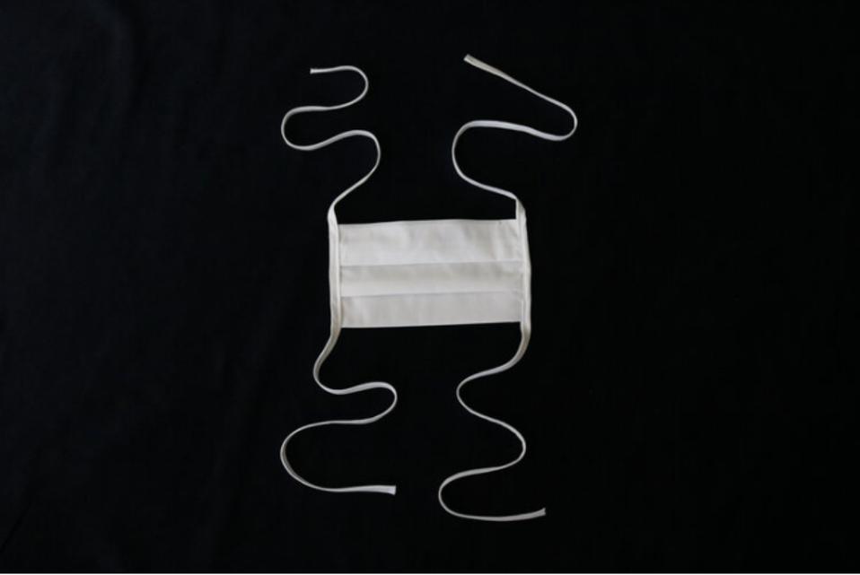 White cotton face mask on dark background.