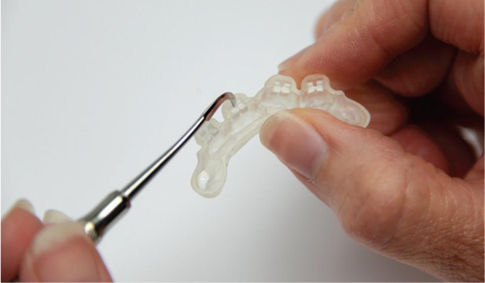 3-D printed brackets are inspected for use.