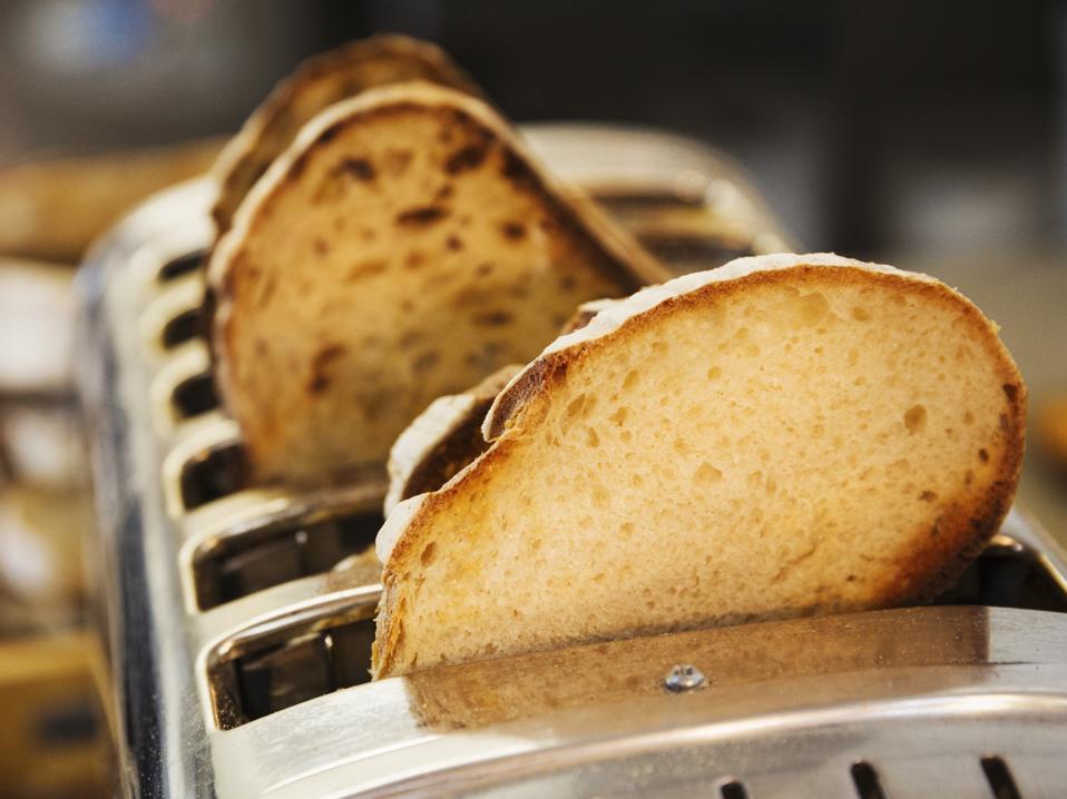 Close up of slices of bread in a stainless steel toaster.