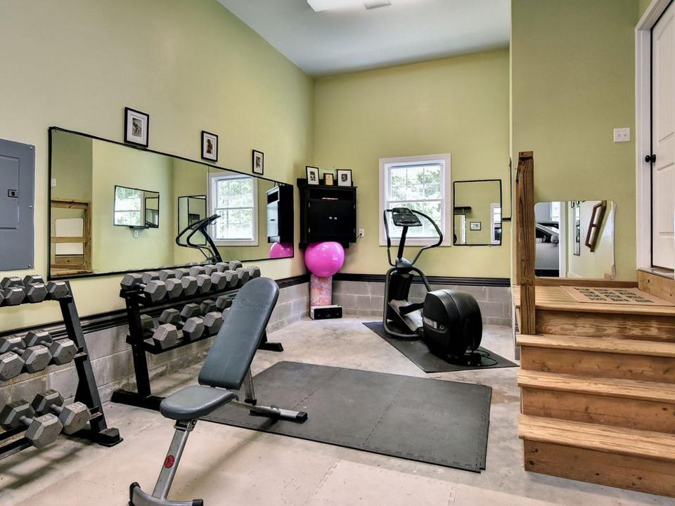 Home gym equipment including barbells and workout mat.
