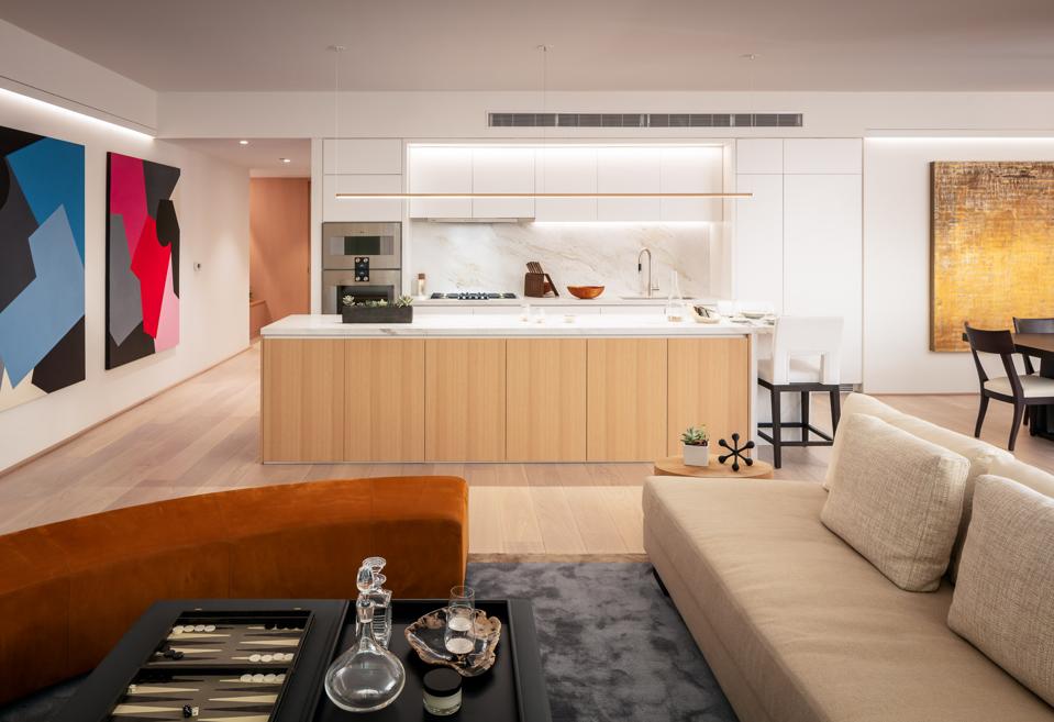 An airy kitchen with marble countertops and neutral furnishings.
