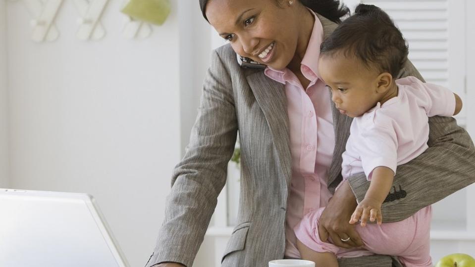 mother working and holding baby