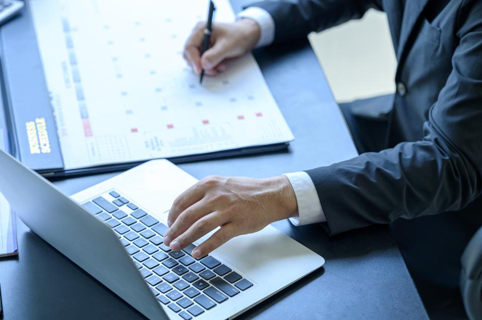 Close-up of businessman making notes on a schedule