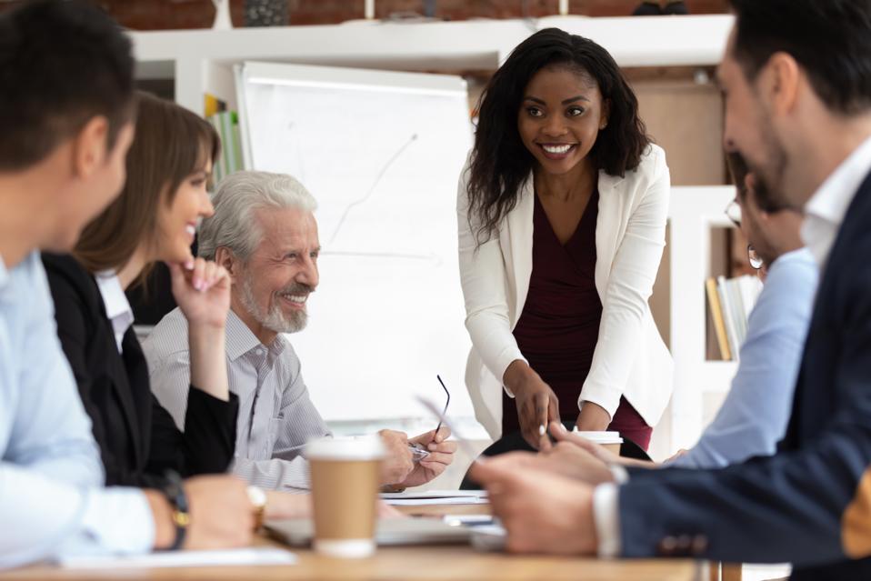 Diverse businesspeople gathered together for negotiations lead by african businesswoman