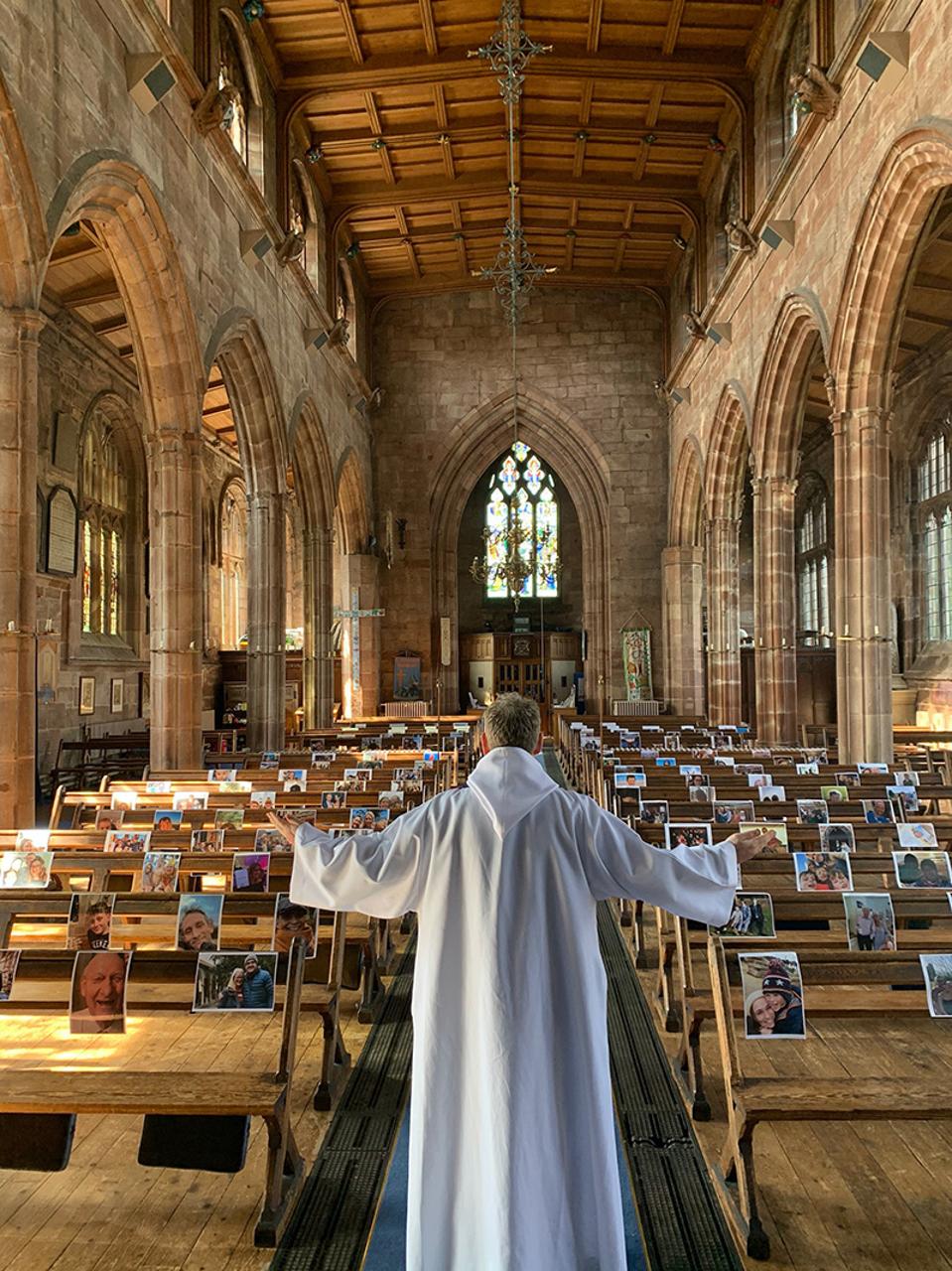 Hold Still, Priest at empty church' during service with photos in the chairs
