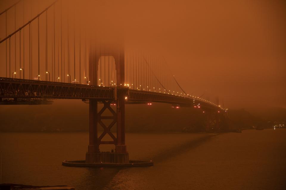 Golden Gate bridge shrouded in orange haze from wildfire smoke and ash