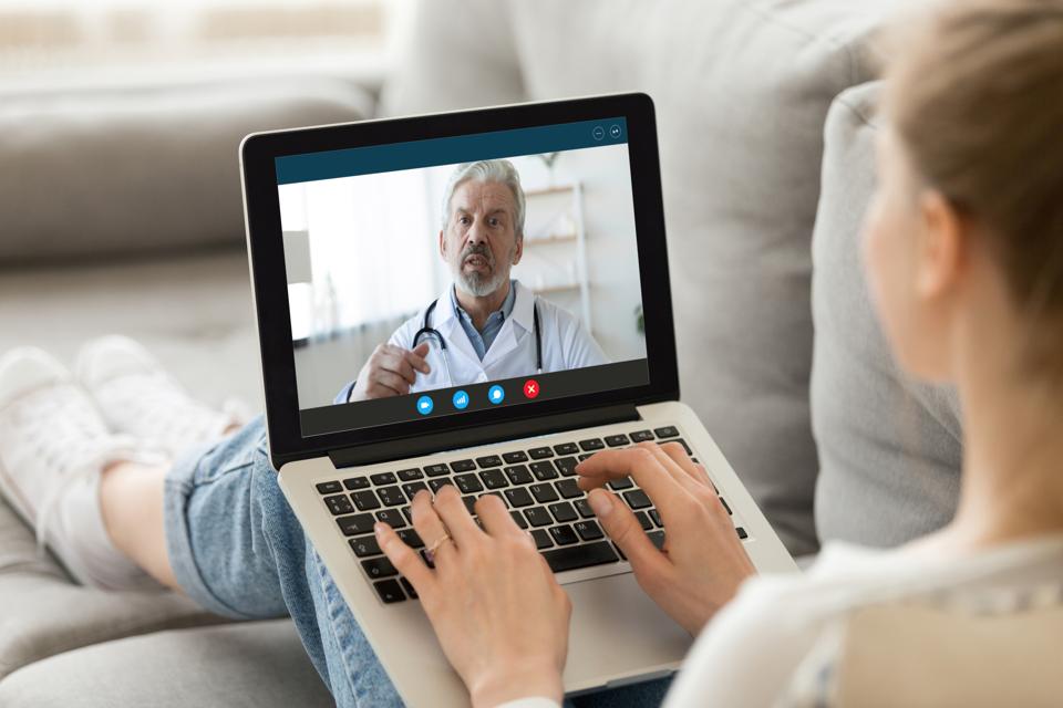Female patient consulting with doctor online using video call