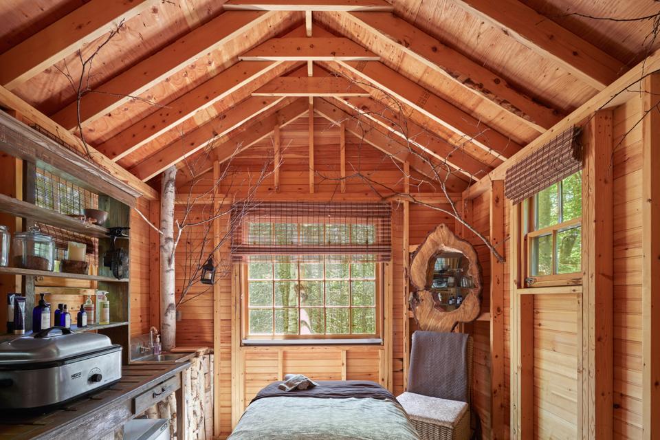 A massage room with light wood, rustic walls