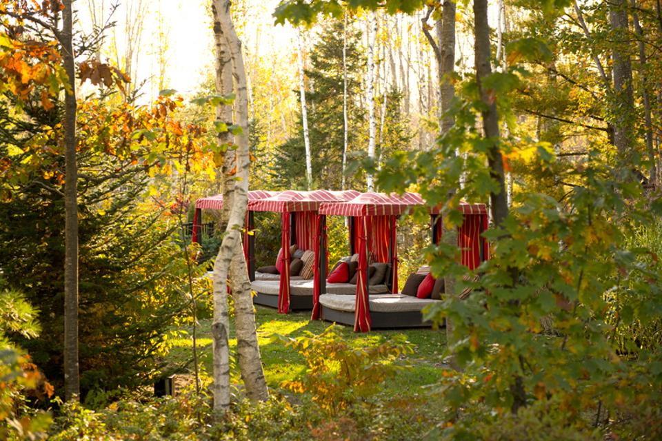 Two red fabric covered day beds in the forest