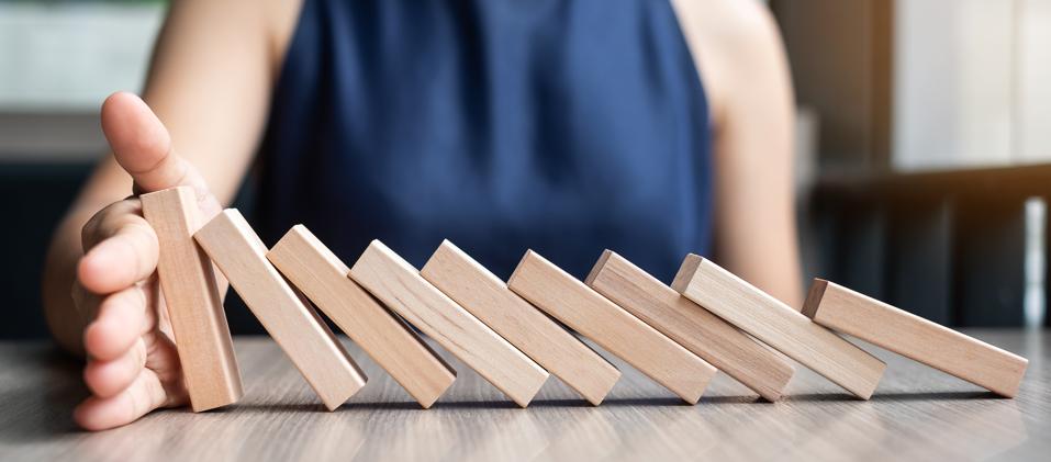 Businesswoman hand Stopping Falling wooden Dominoes. Business, Risk Management, Solution and strategy Concepts